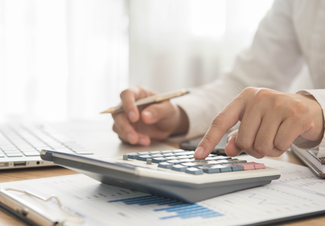Person Working on Calculator 